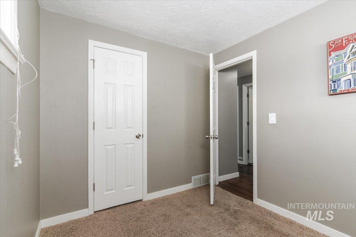 Unfurnished bedroom with carpet floors and a textured ceiling