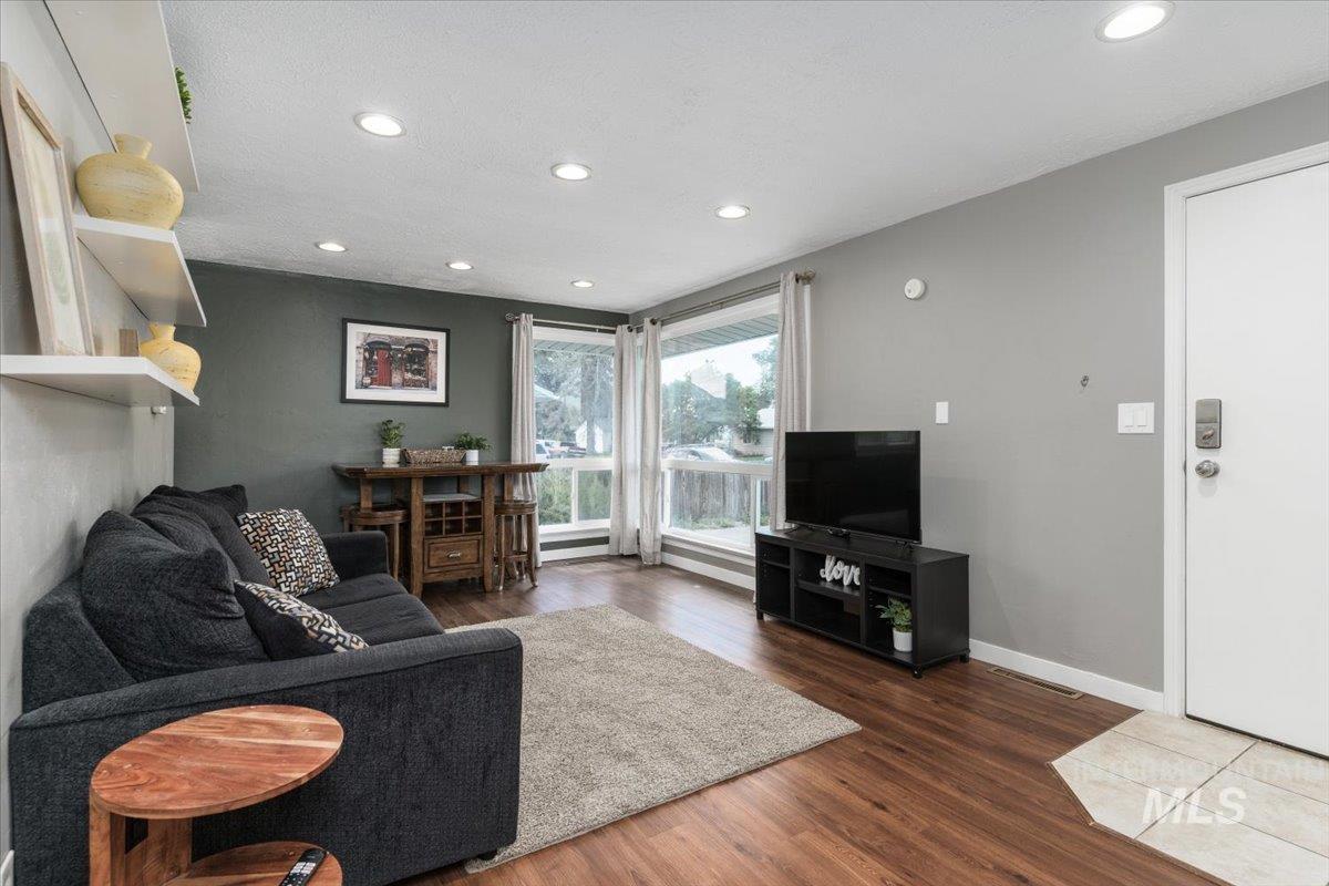 Living room with dark wood-style floors and recessed lighting