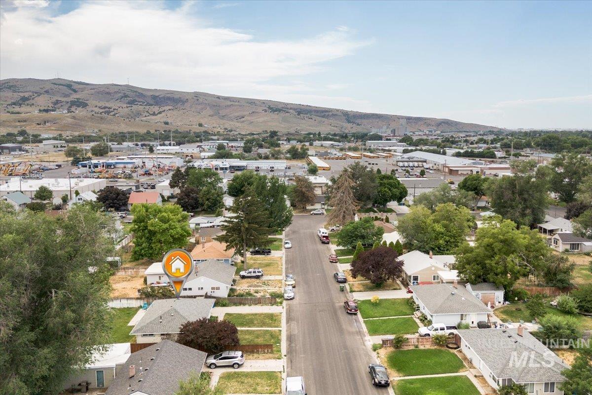 Aerial view of property's location with nearby suburban area and a mountain backdrop