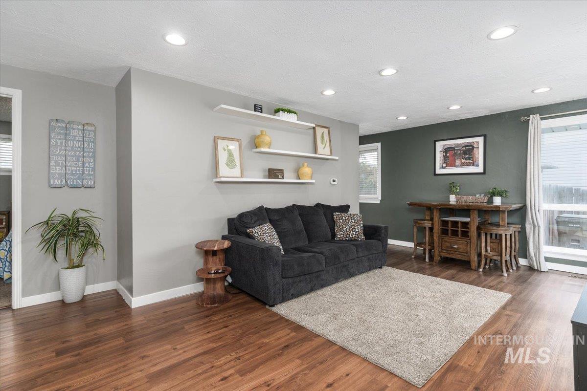 Living area featuring a textured ceiling, dark wood-style flooring, and recessed lighting
