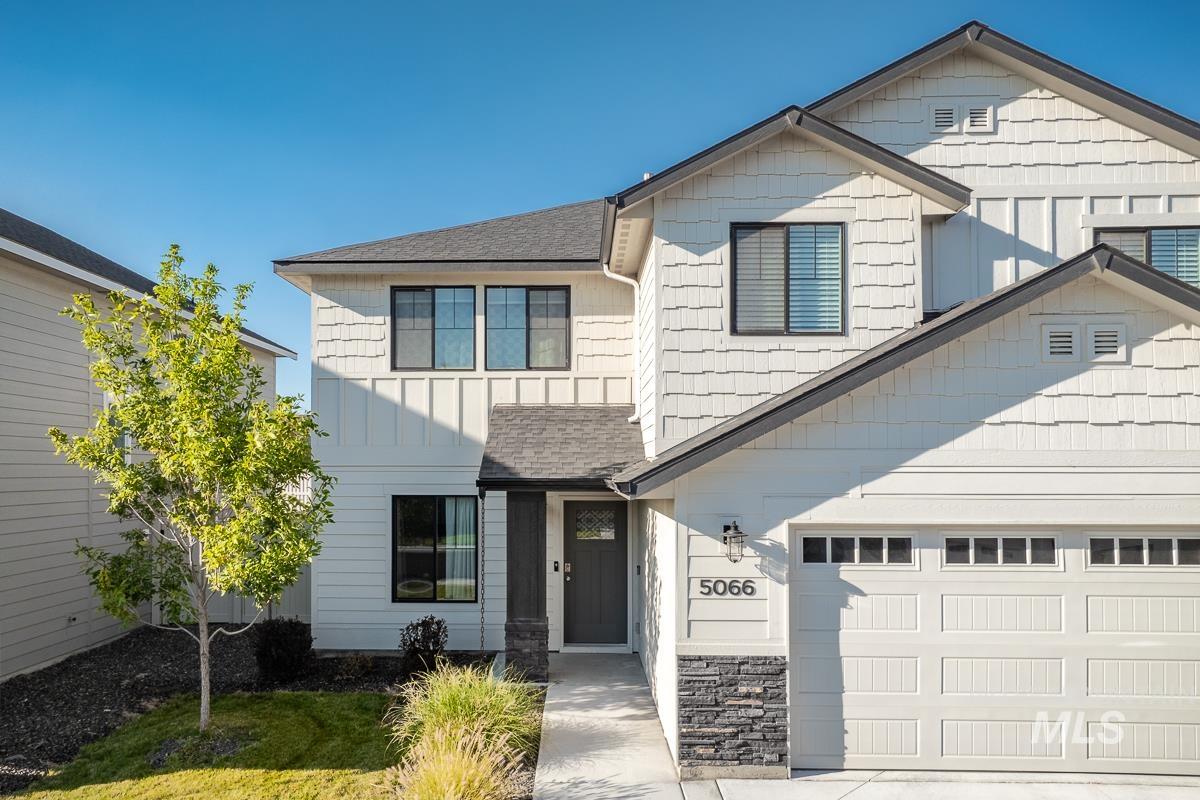 Craftsman inspired home with board and batten siding, roof with shingles, a garage, and concrete driveway