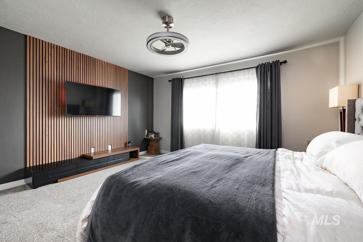 Bedroom with carpet, a textured ceiling, and an accent wall