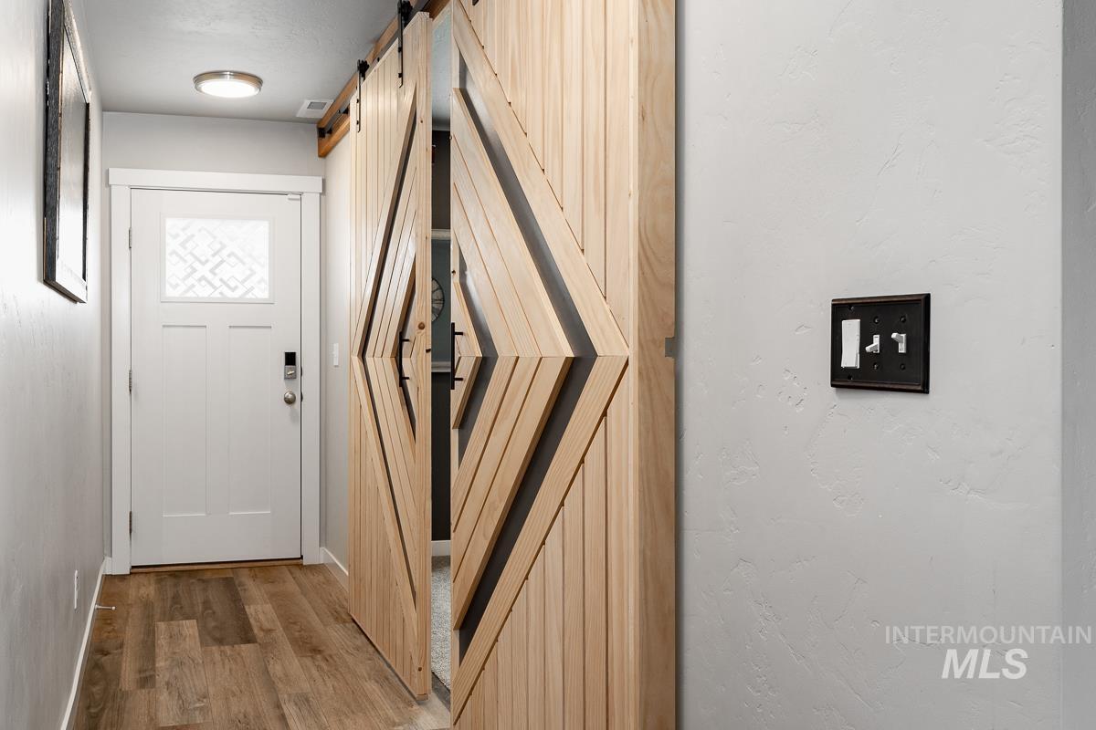 Entryway with a barn door and wood finished floors