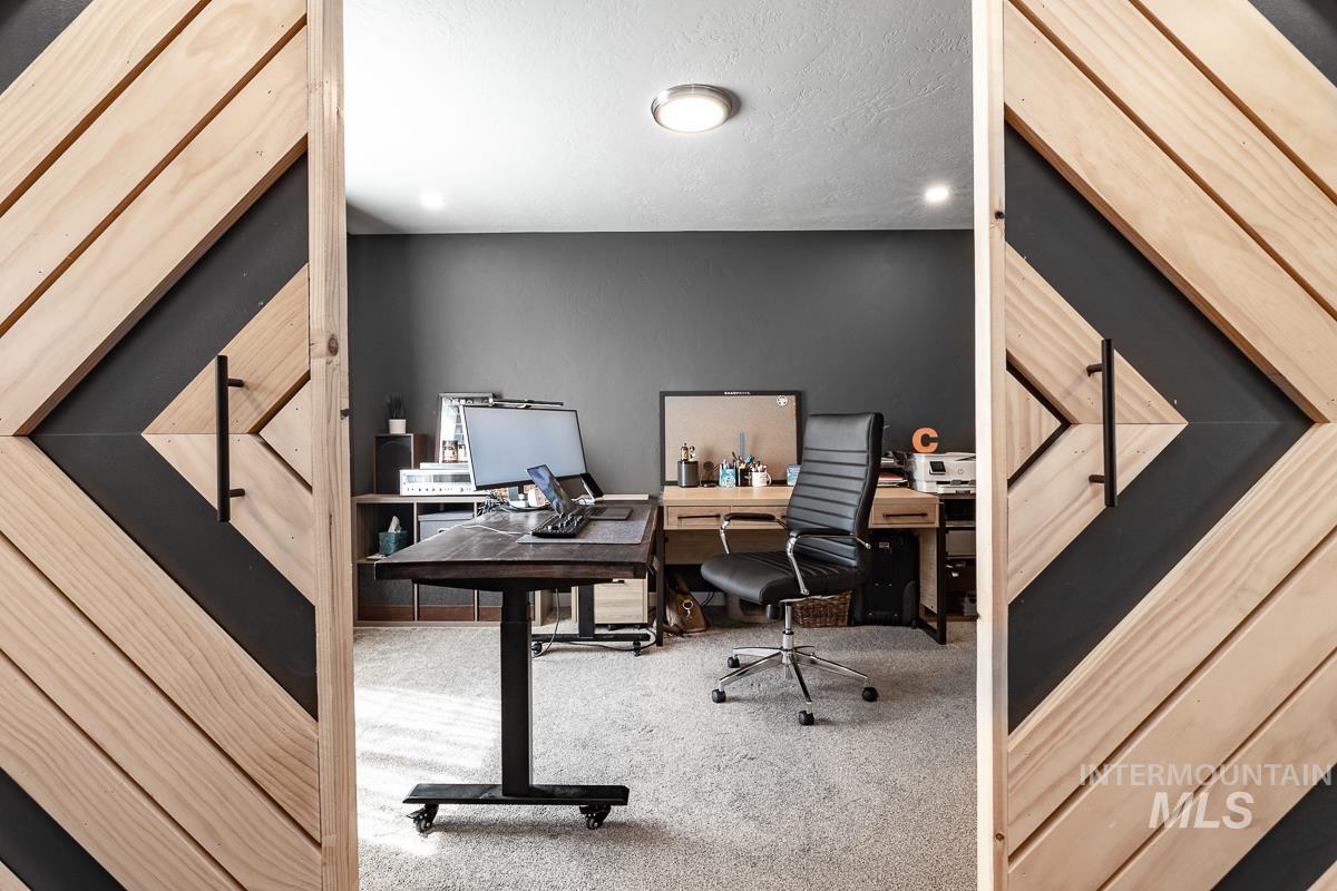 Office area featuring carpet and a textured ceiling