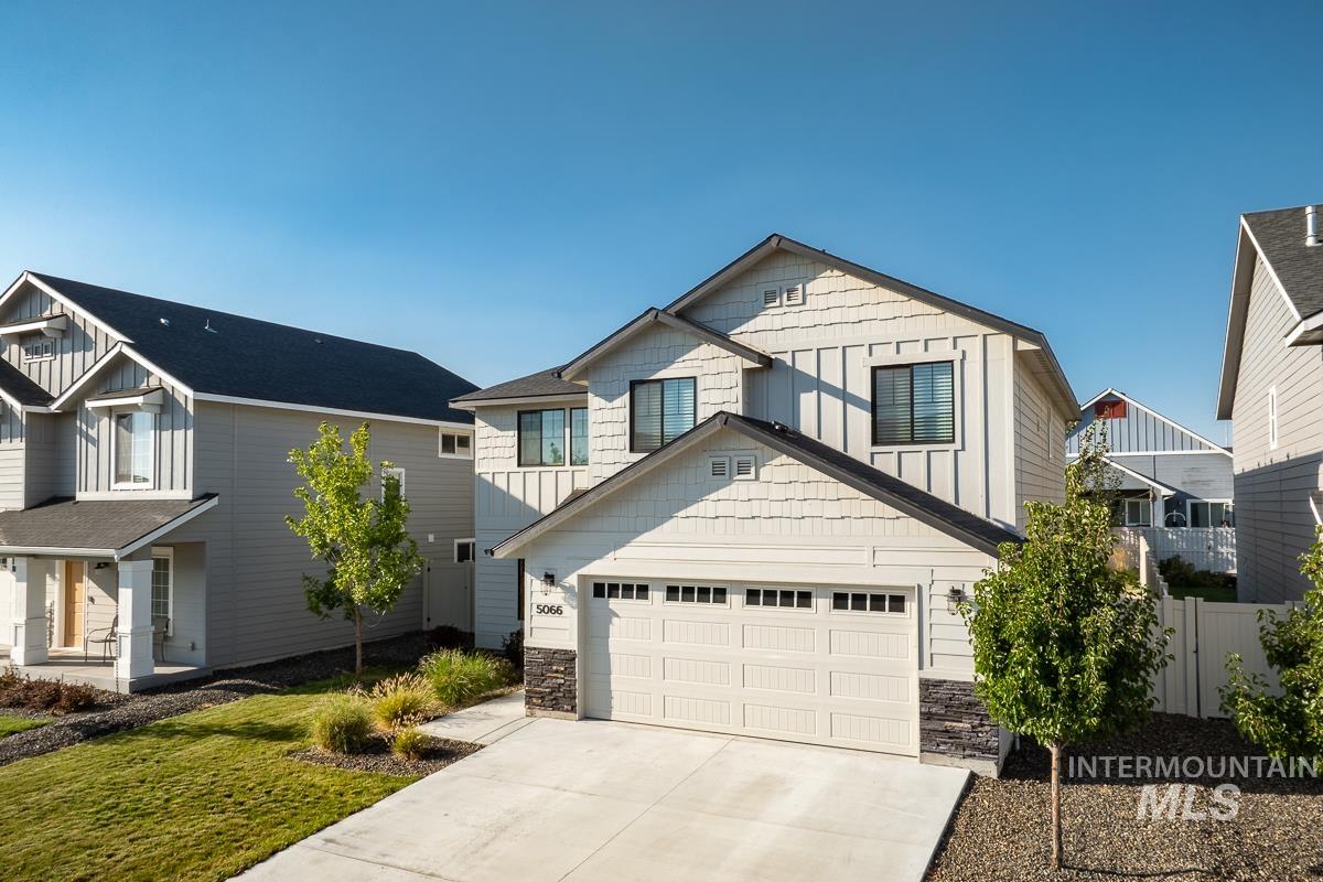 Craftsman-style home with stone siding, concrete driveway, a garage, and board and batten siding
