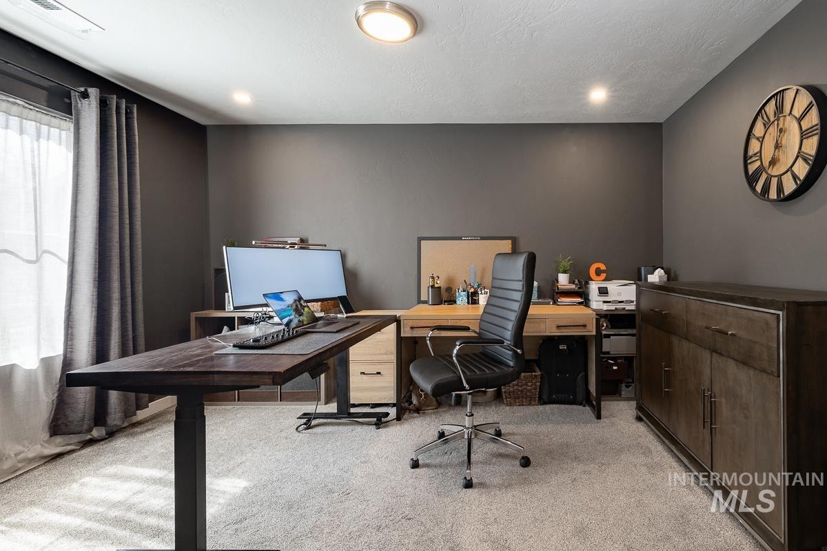 Office featuring light carpet and a textured ceiling
