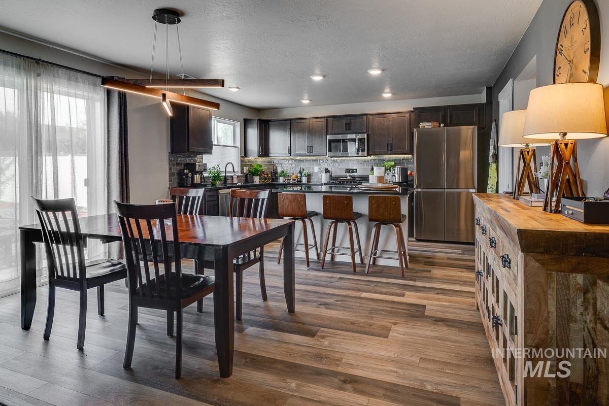 Dining room featuring dark wood-style flooring and a textured ceiling