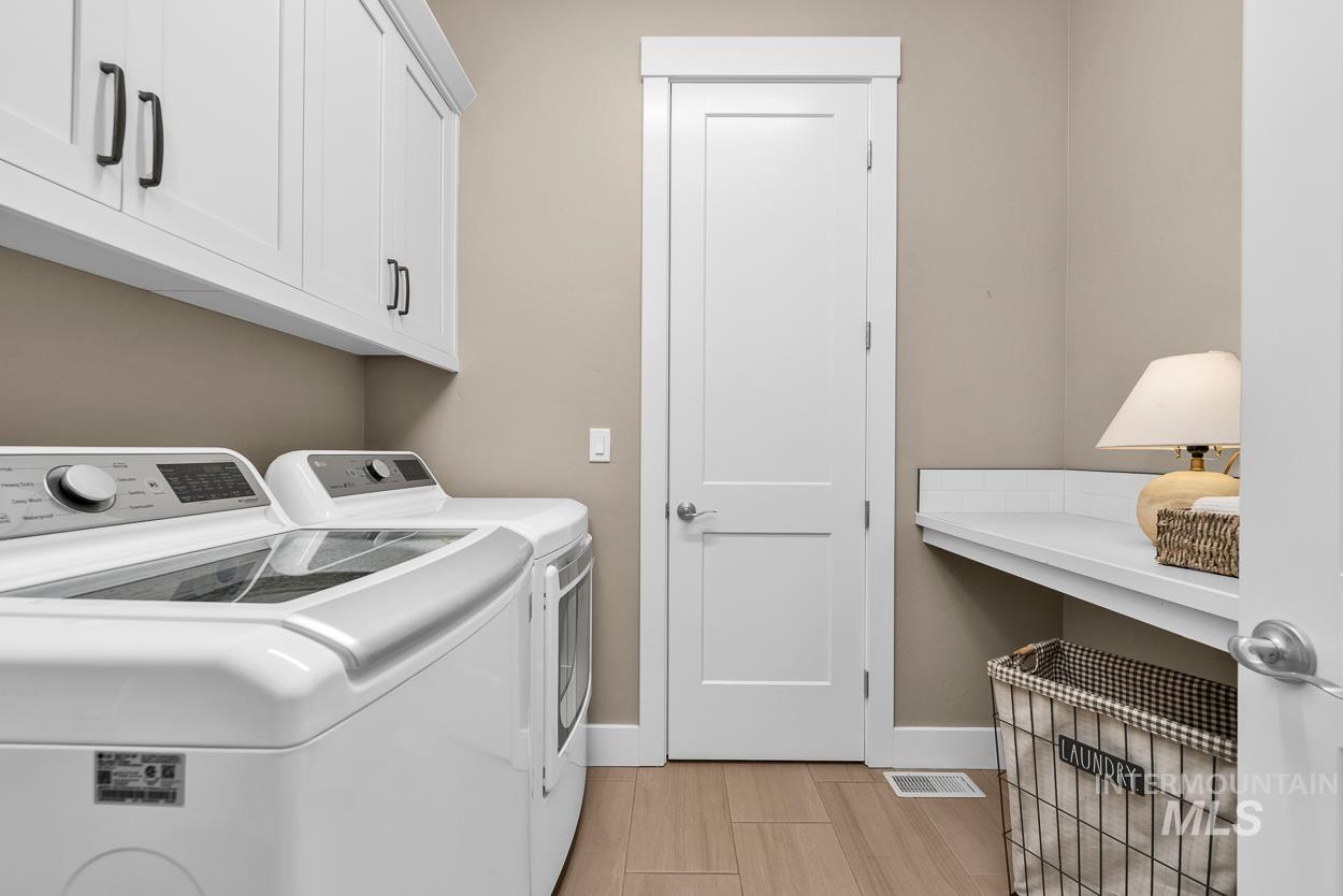 Washroom with washing machine and dryer and cabinet space