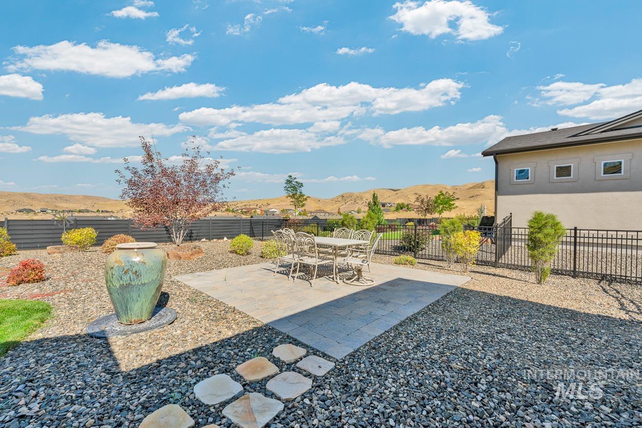Fenced backyard with a patio area, a mountain view, and outdoor dining space