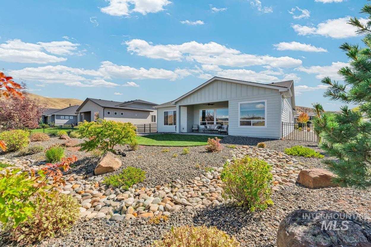 Rear view of property with a patio area, a fenced backyard, board and batten siding, and ceiling fan