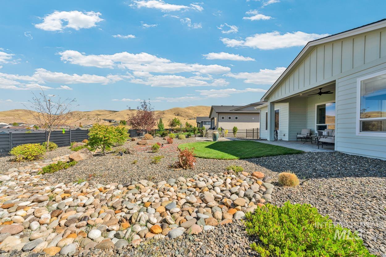 Fenced backyard with a mountain view, a patio, and a ceiling fan