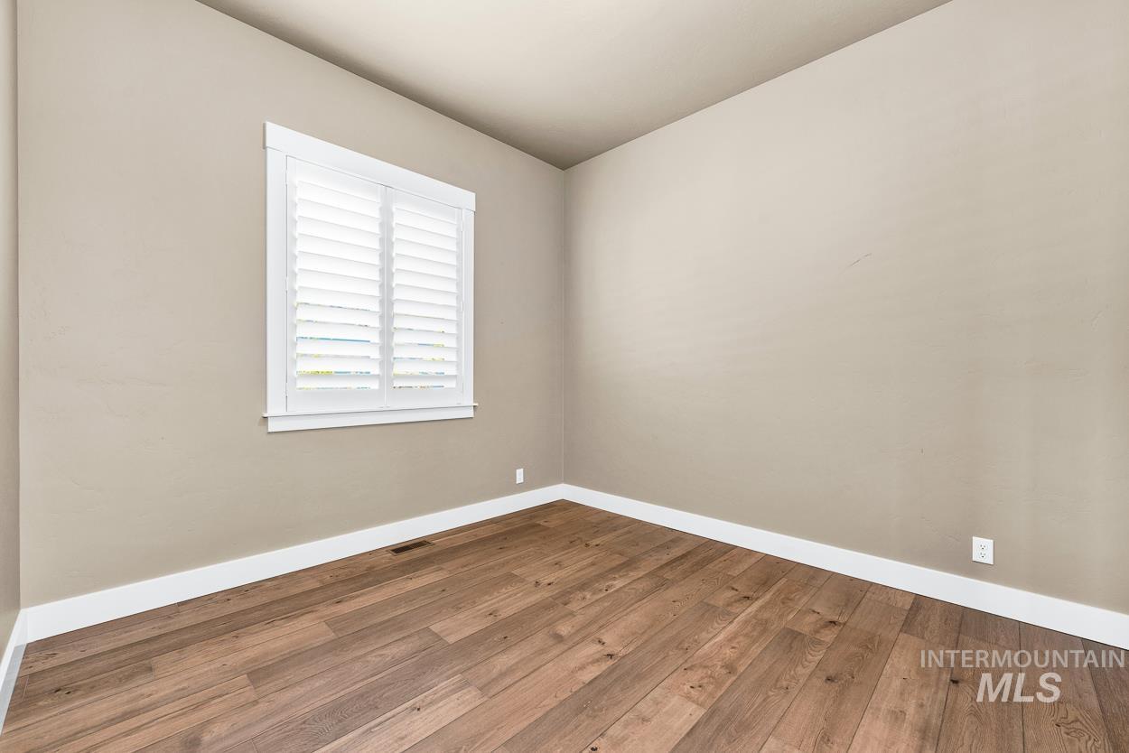 Empty room featuring baseboards and wood finished floors