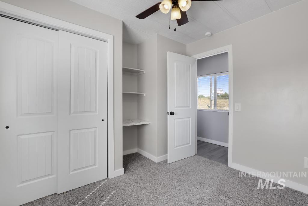 Unfurnished bedroom with light carpet, a closet, and a ceiling fan