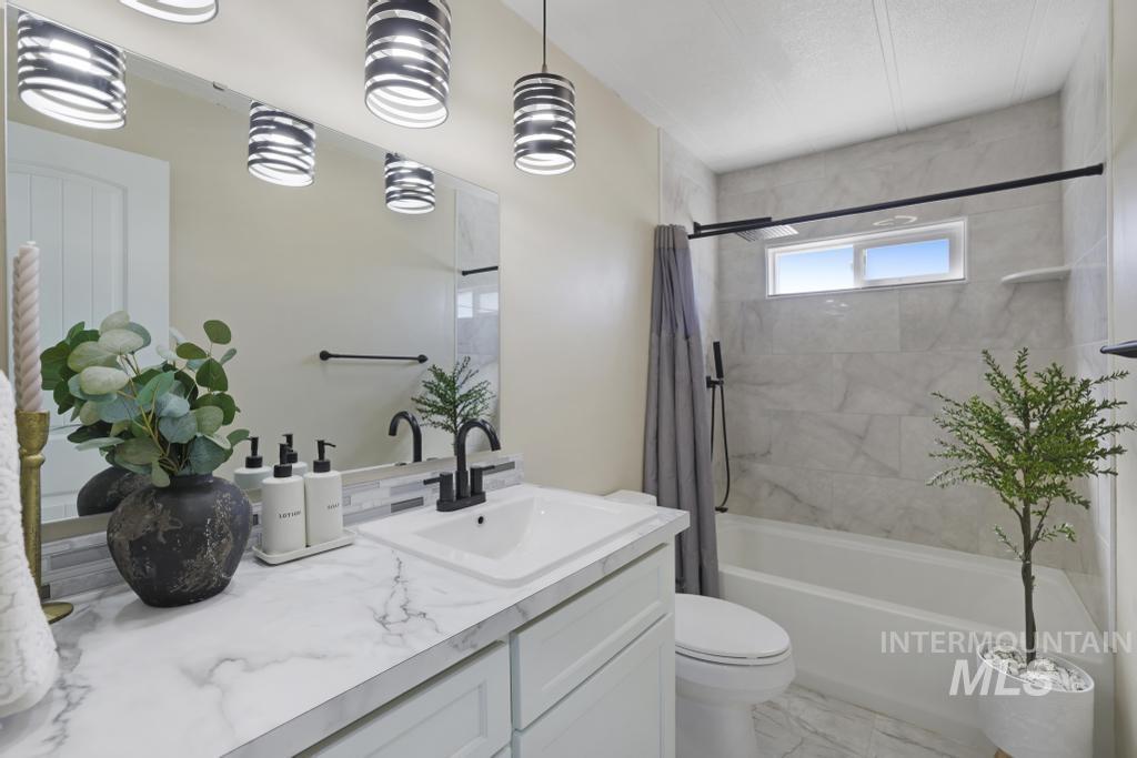 Bathroom featuring shower / tub combo with curtain and vanity