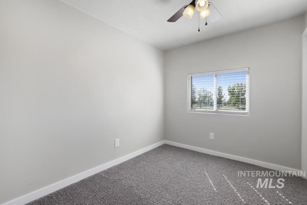 Unfurnished room featuring carpet and ceiling fan