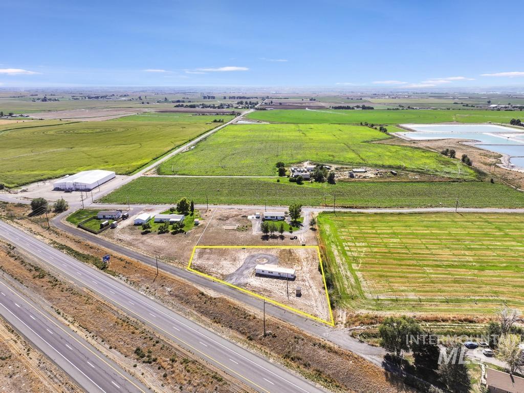 Aerial view of sparsely populated area featuring property parcel outlined and large plots for crops