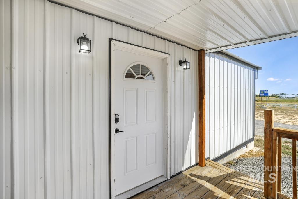 Doorway to property featuring board and batten siding and a wooden deck