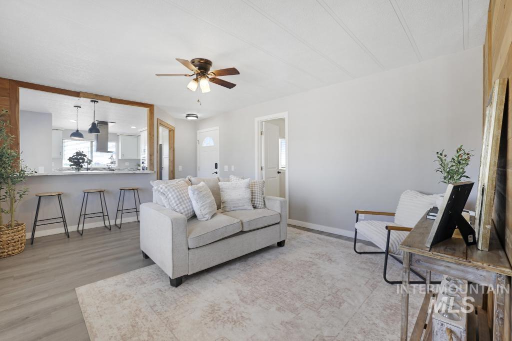 Living area with light wood-style flooring and a ceiling fan