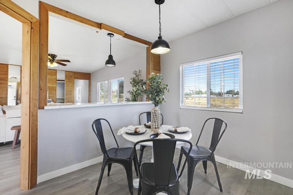 Dining area featuring wood finished floors, beamed ceiling, and ceiling fan