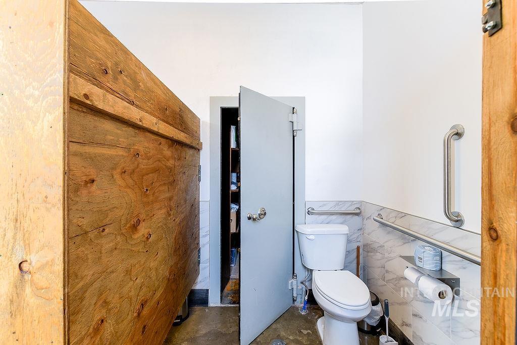 Bathroom with tile walls and a wainscoted wall