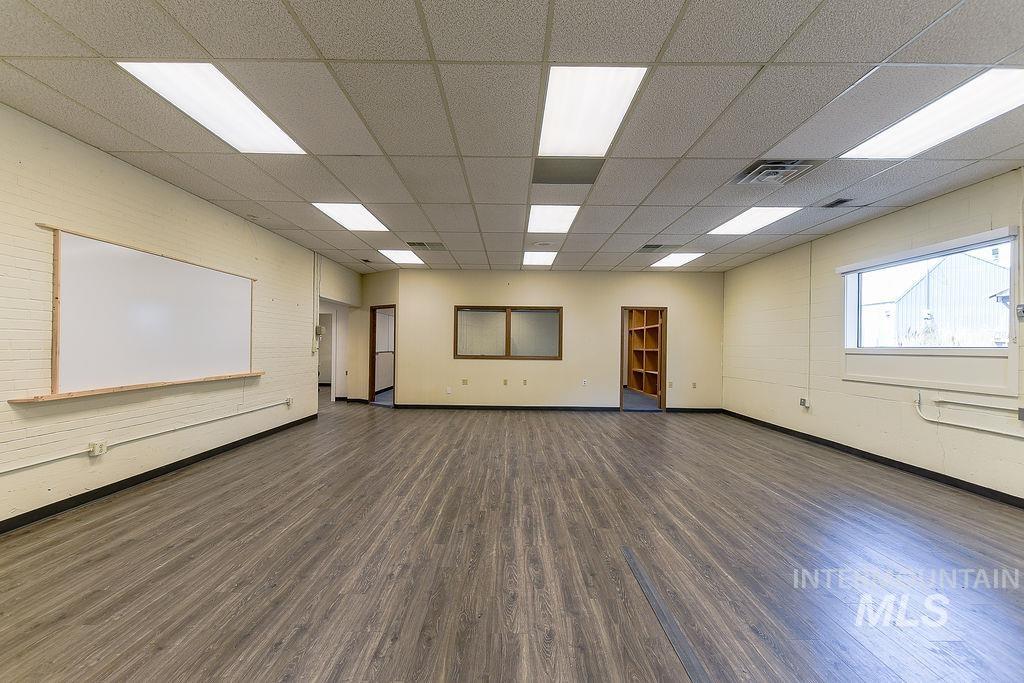 Spare room featuring dark wood-type flooring and a paneled ceiling