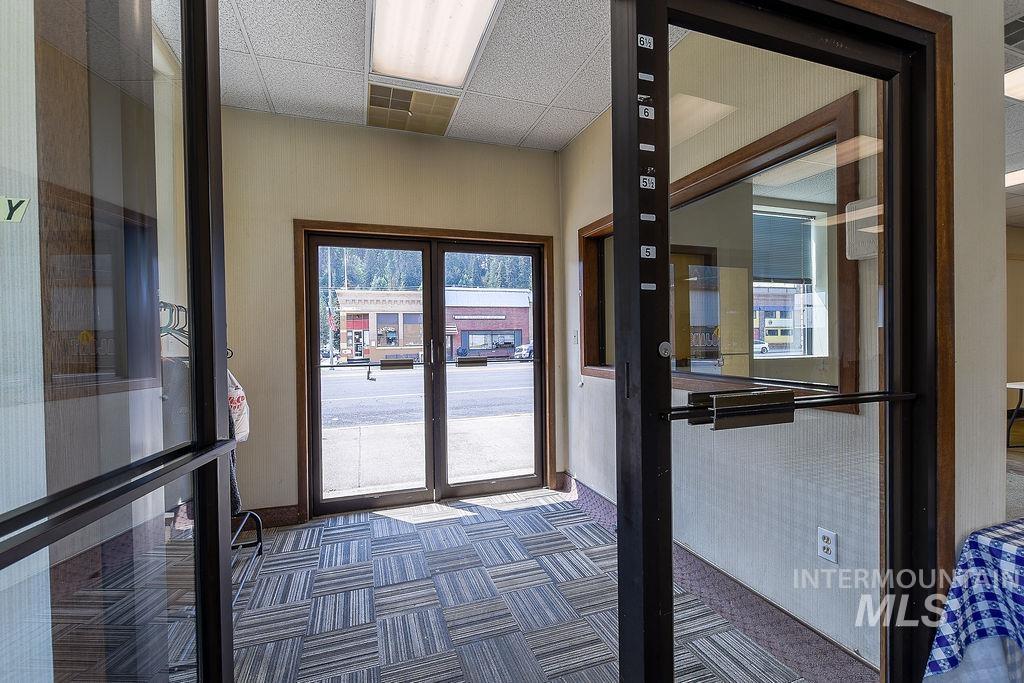 Entryway with french doors, carpet floors, and a drop ceiling