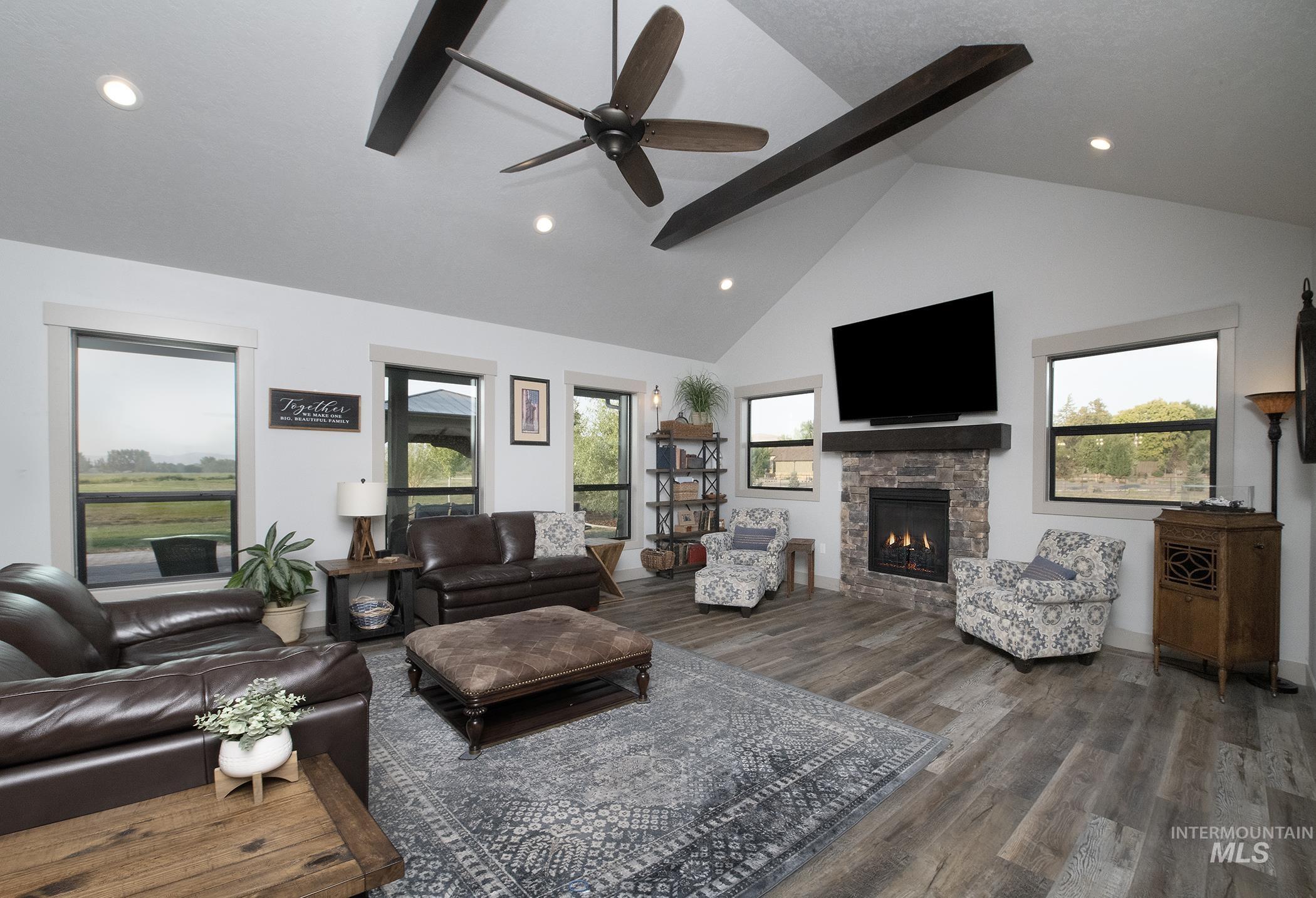 Living area featuring beamed ceiling, a fireplace, high vaulted ceiling, recessed lighting, and dark wood-style floors