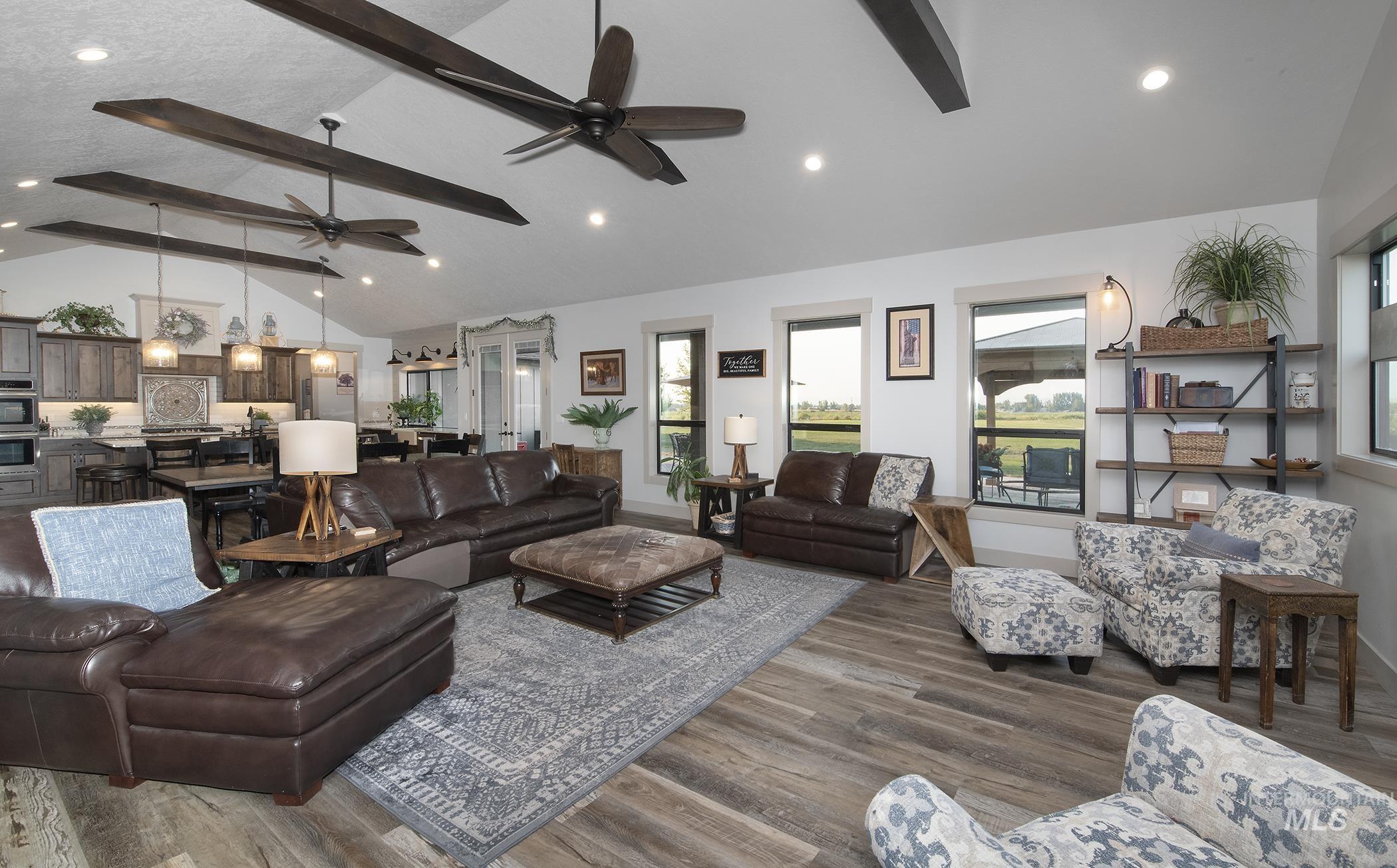 Living area featuring beamed ceiling, recessed lighting, dark wood finished floors, high vaulted ceiling, and a ceiling fan