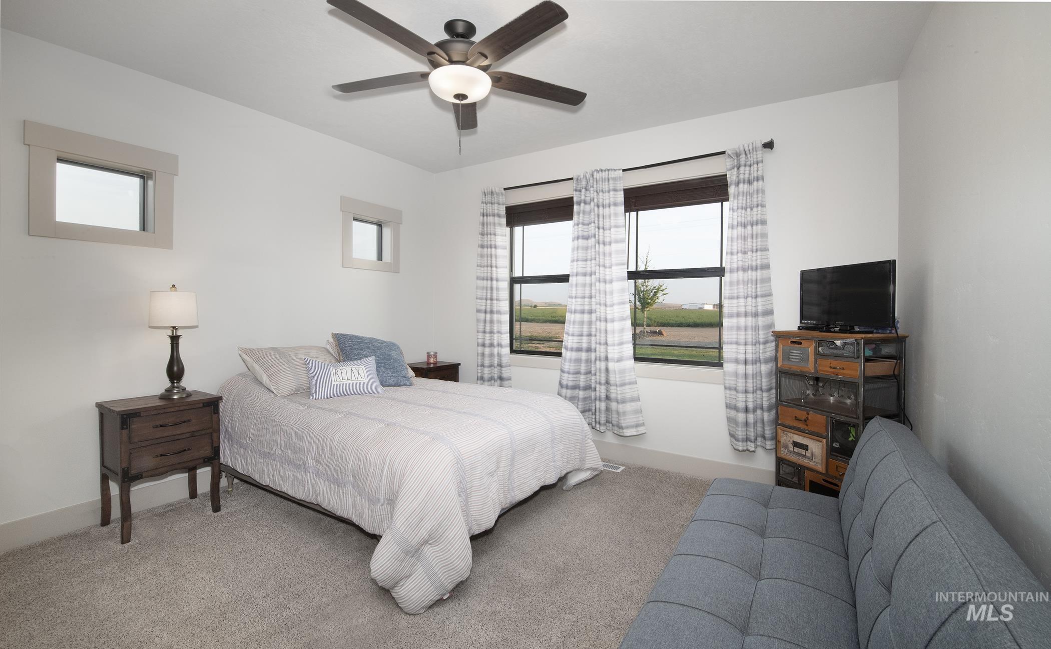 Bedroom with light carpet and ceiling fan