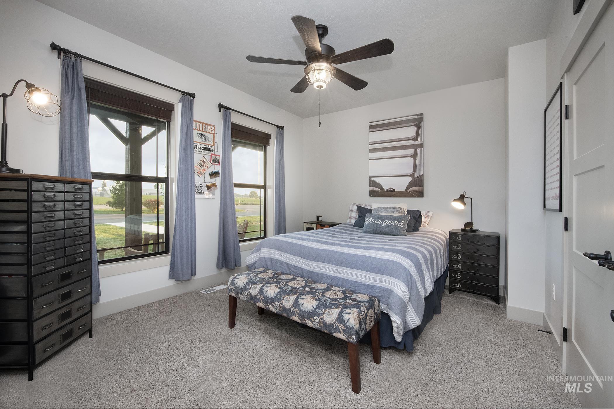 Bedroom with light carpet and a ceiling fan