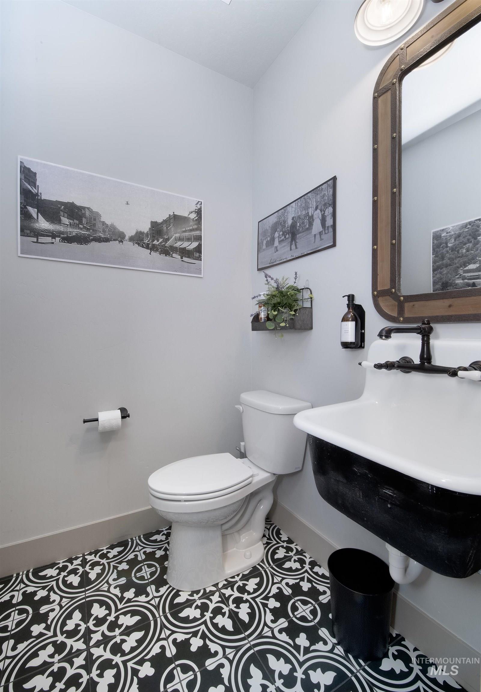 Half bathroom with baseboards and tile patterned flooring