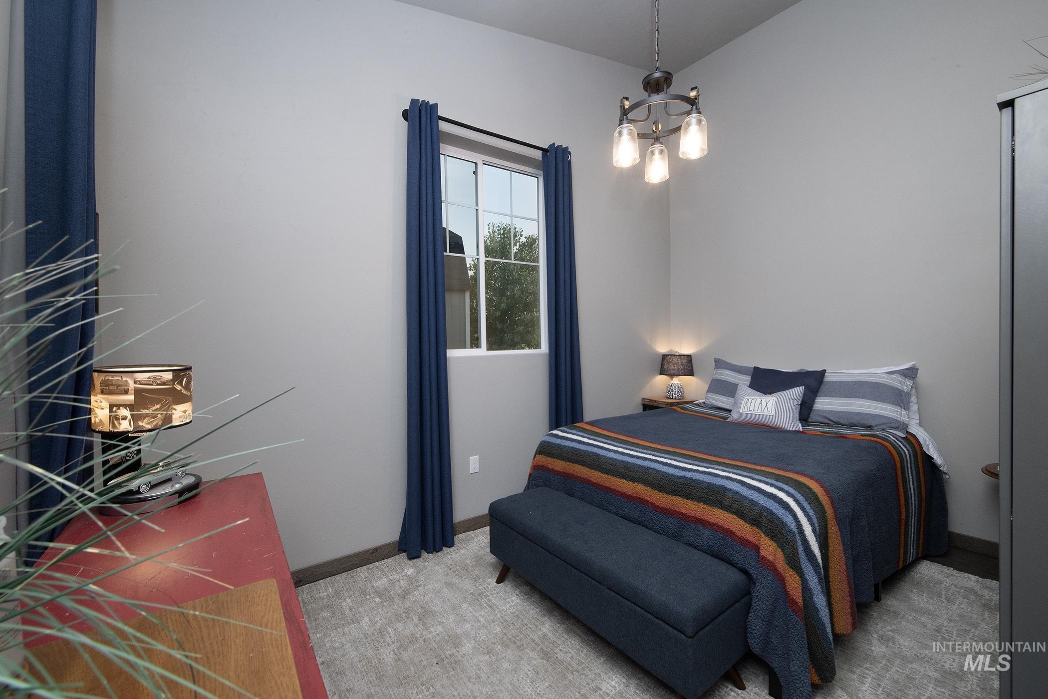 Bedroom featuring a chandelier and light colored carpet