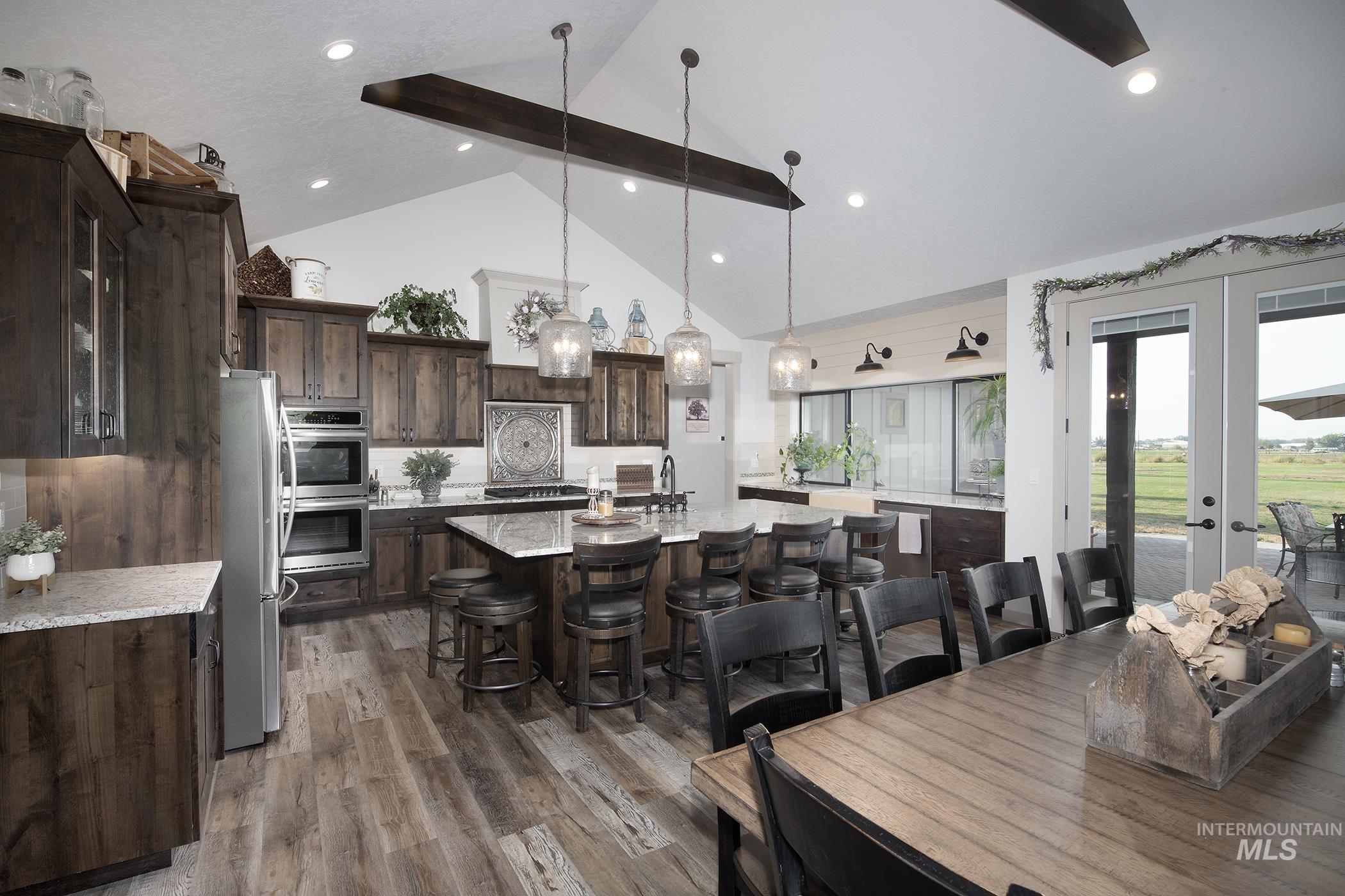 Dining area with french doors, dark wood finished floors, and high vaulted ceiling