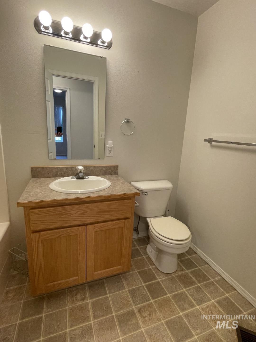 Bathroom with vanity and dark tile patterned floors