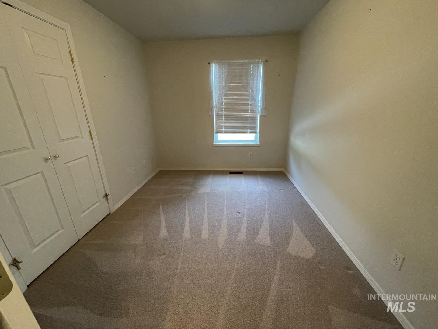 Unfurnished bedroom with carpet floors and baseboards