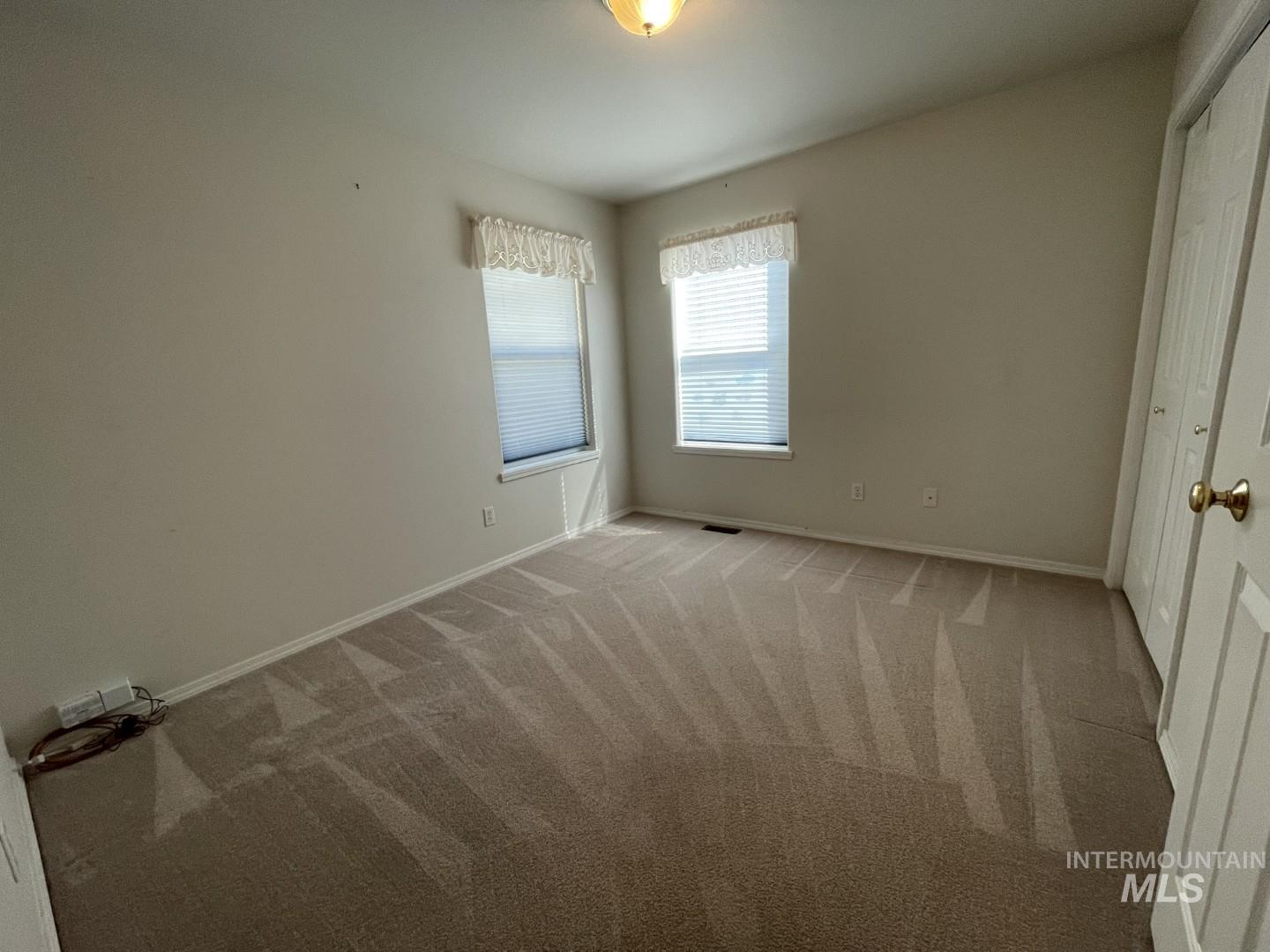 Unfurnished bedroom featuring light carpet and a closet