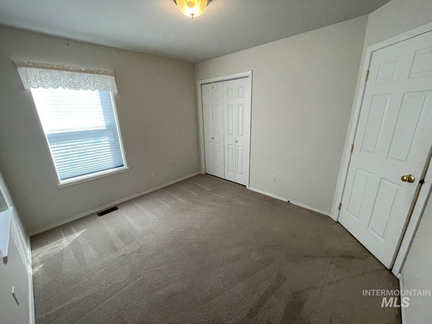 Unfurnished bedroom with carpet and a closet