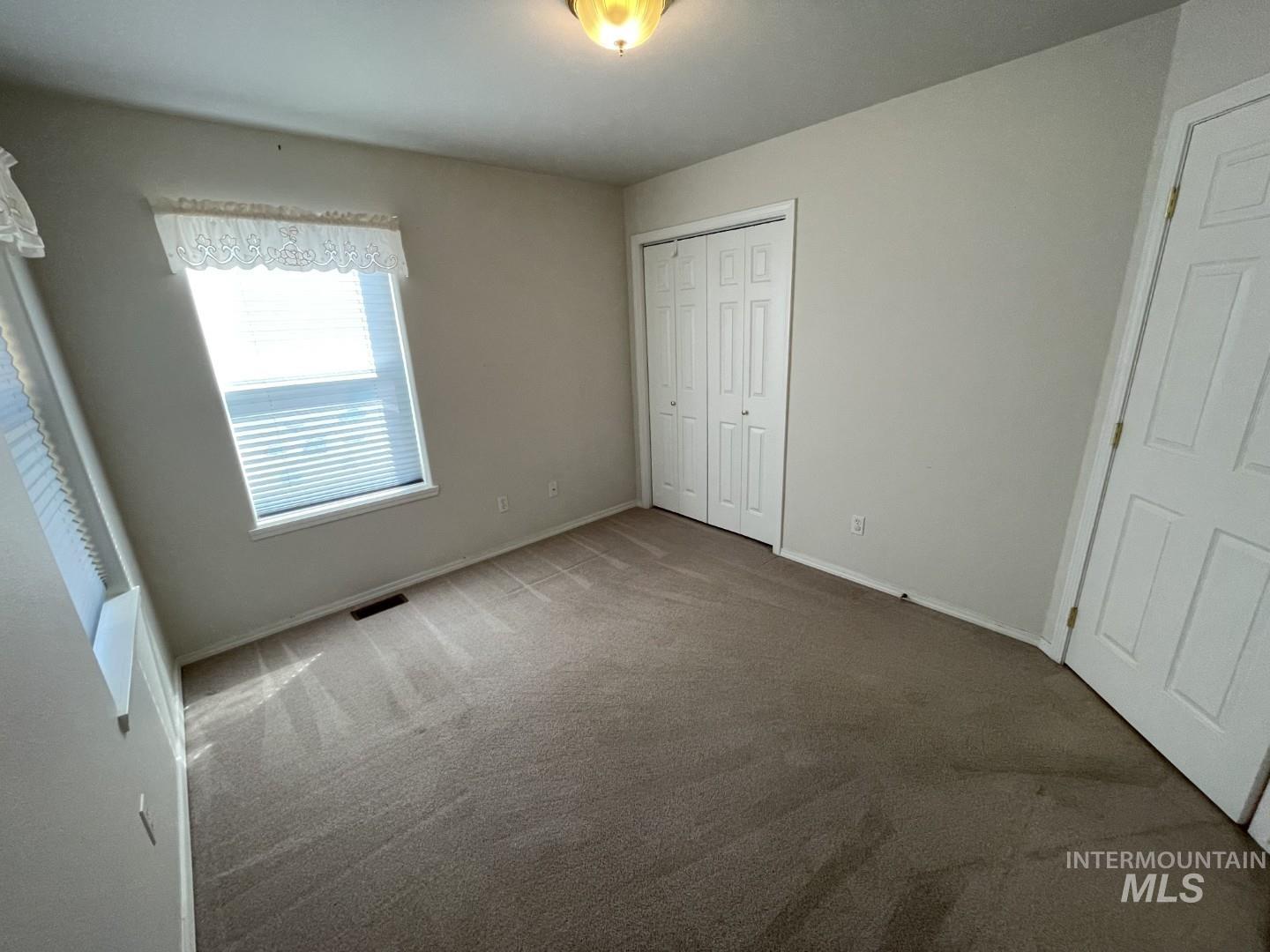 Unfurnished bedroom with carpet and a closet