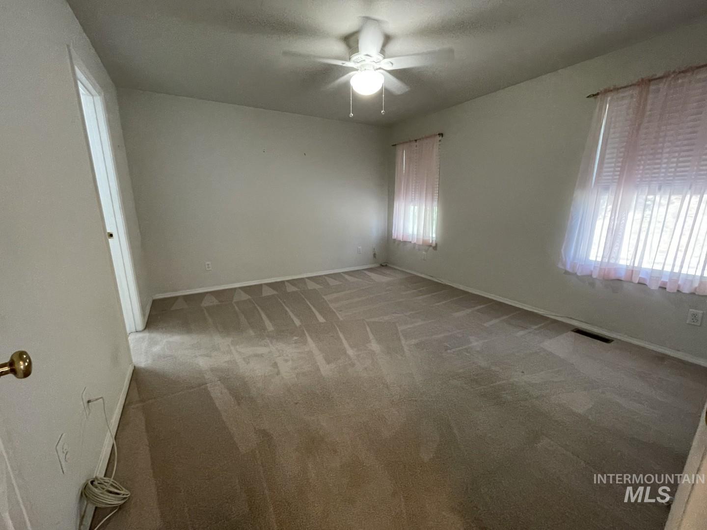 Unfurnished room with light colored carpet, a textured ceiling, and a ceiling fan
