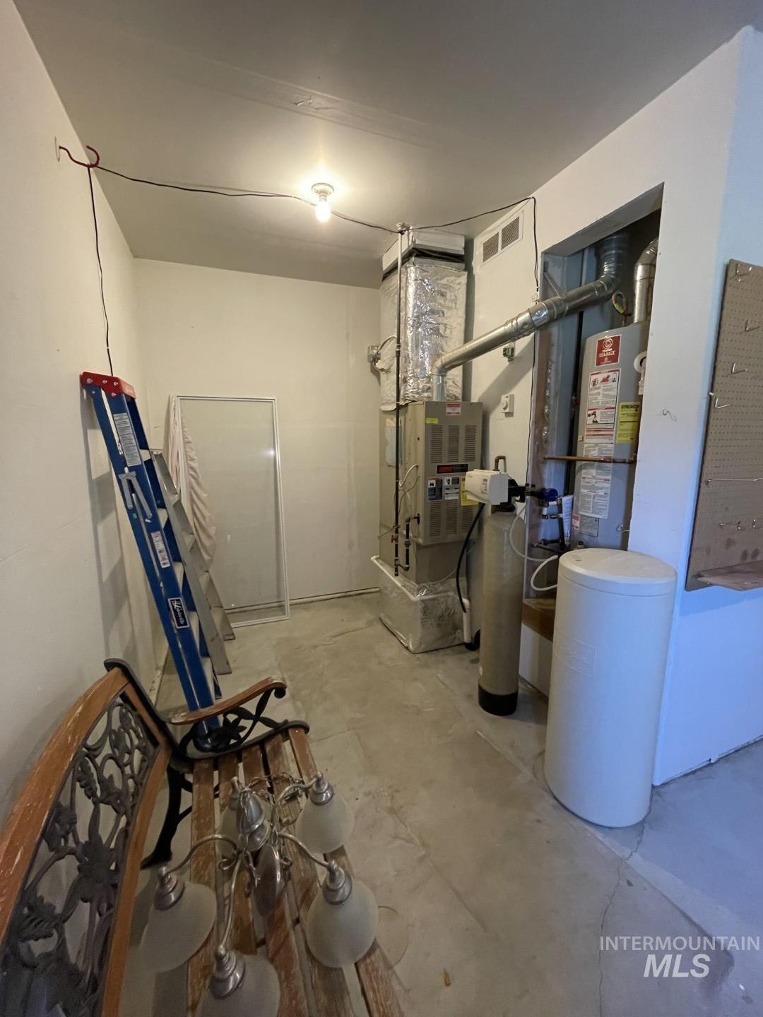 Utility room with gas water heater and heating unit