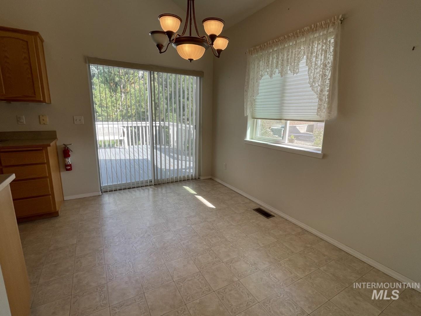 Unfurnished dining area featuring plenty of natural light and a chandelier