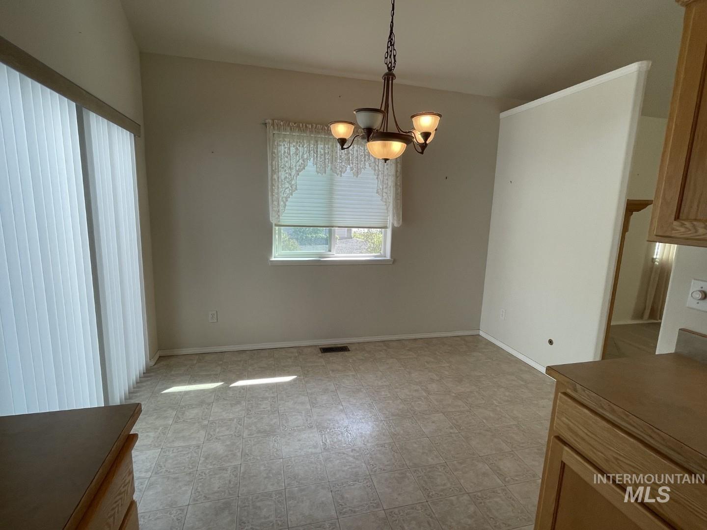 Unfurnished dining area with a chandelier
