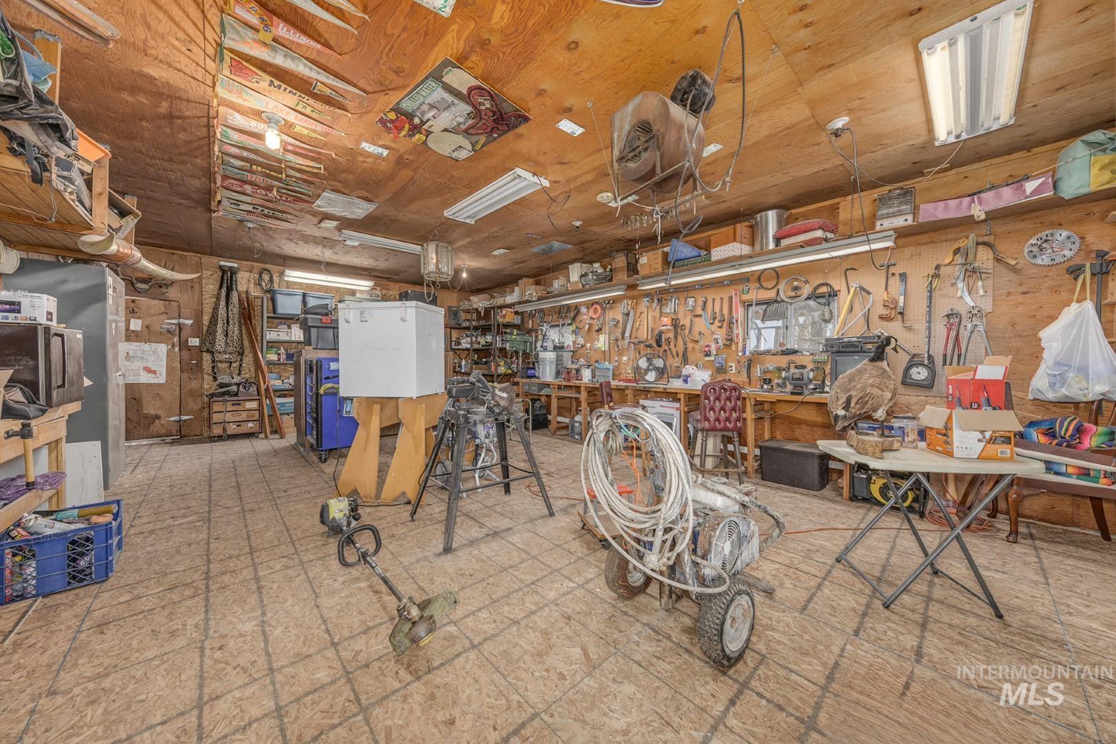 Miscellaneous room with a workshop area, tile patterned floors, and wood ceiling