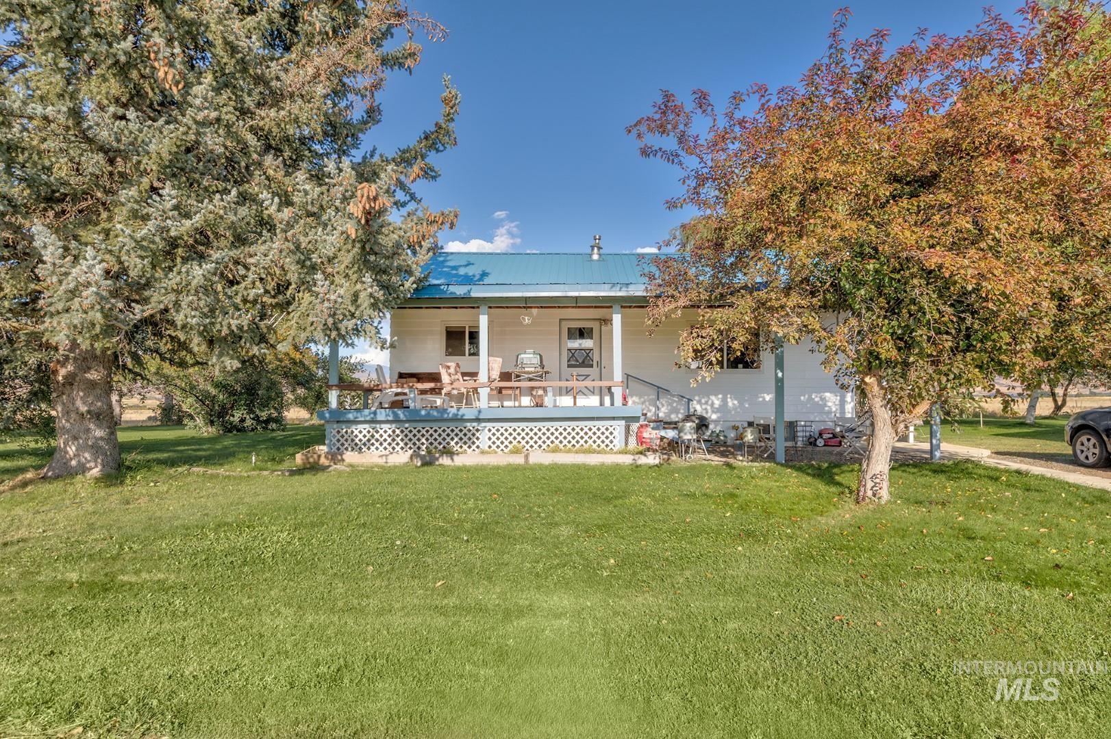 Rear view of property featuring a yard, a metal roof, and covered porch
