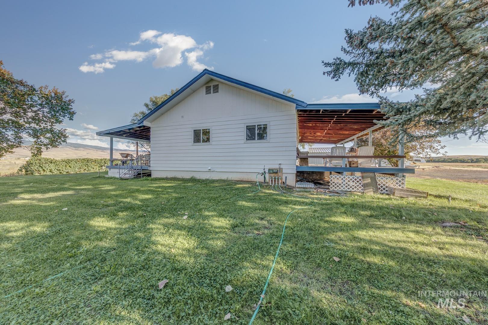 Back of property featuring a wooden deck, a yard, and board and batten siding