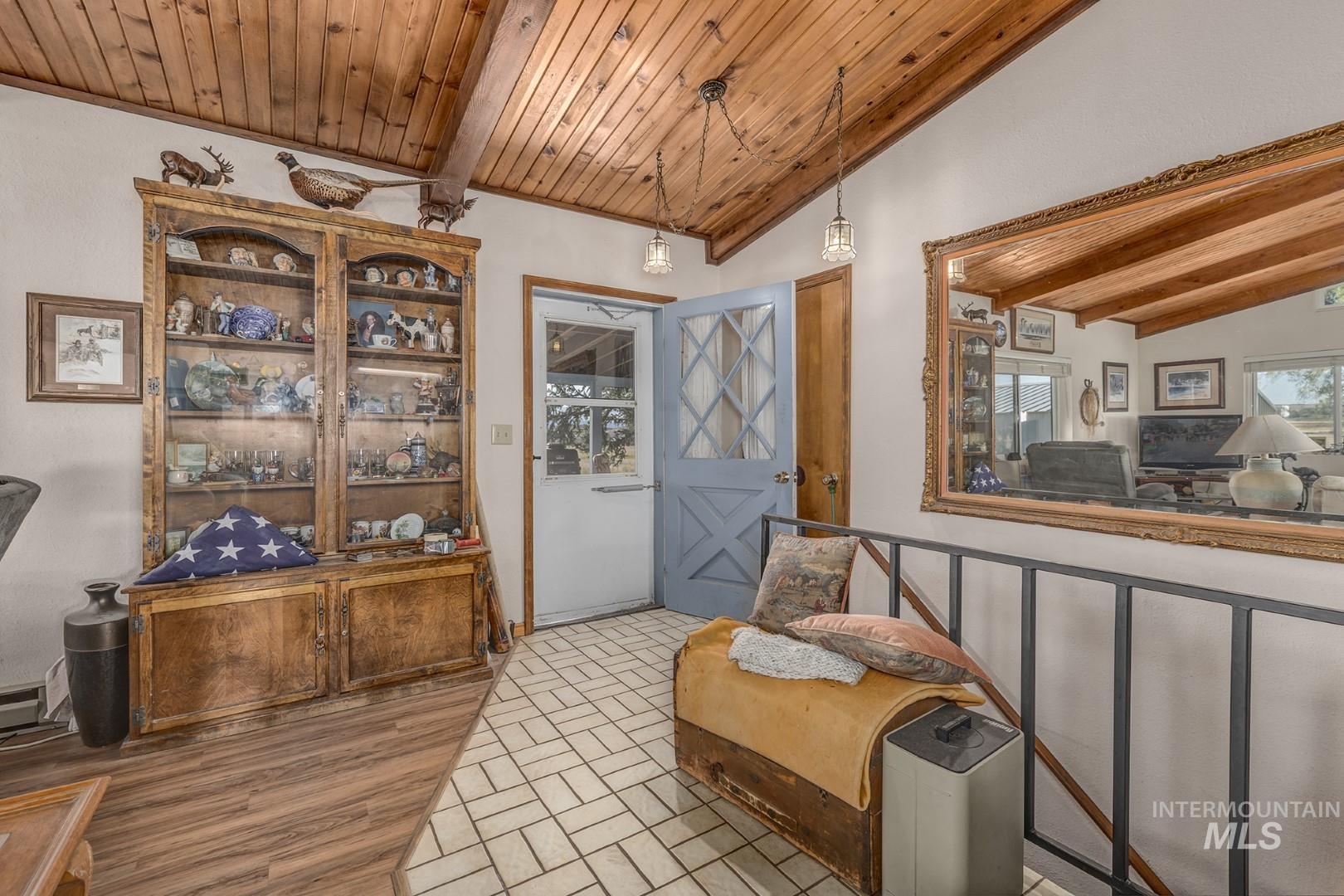 Sitting room featuring wood ceiling, healthy amount of natural light, and brick patterned floors