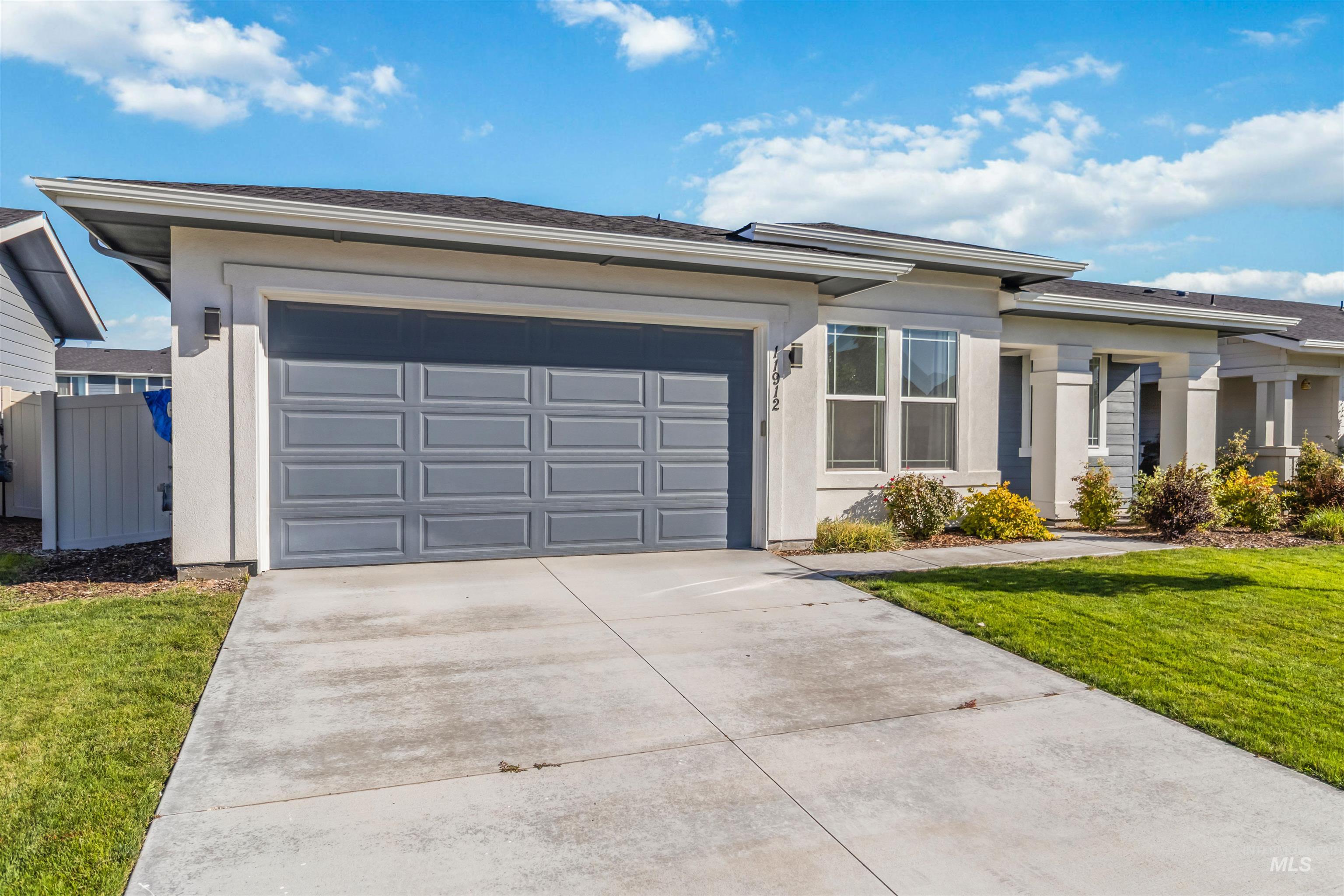 Prairie-style house with driveway, a garage, and stucco siding