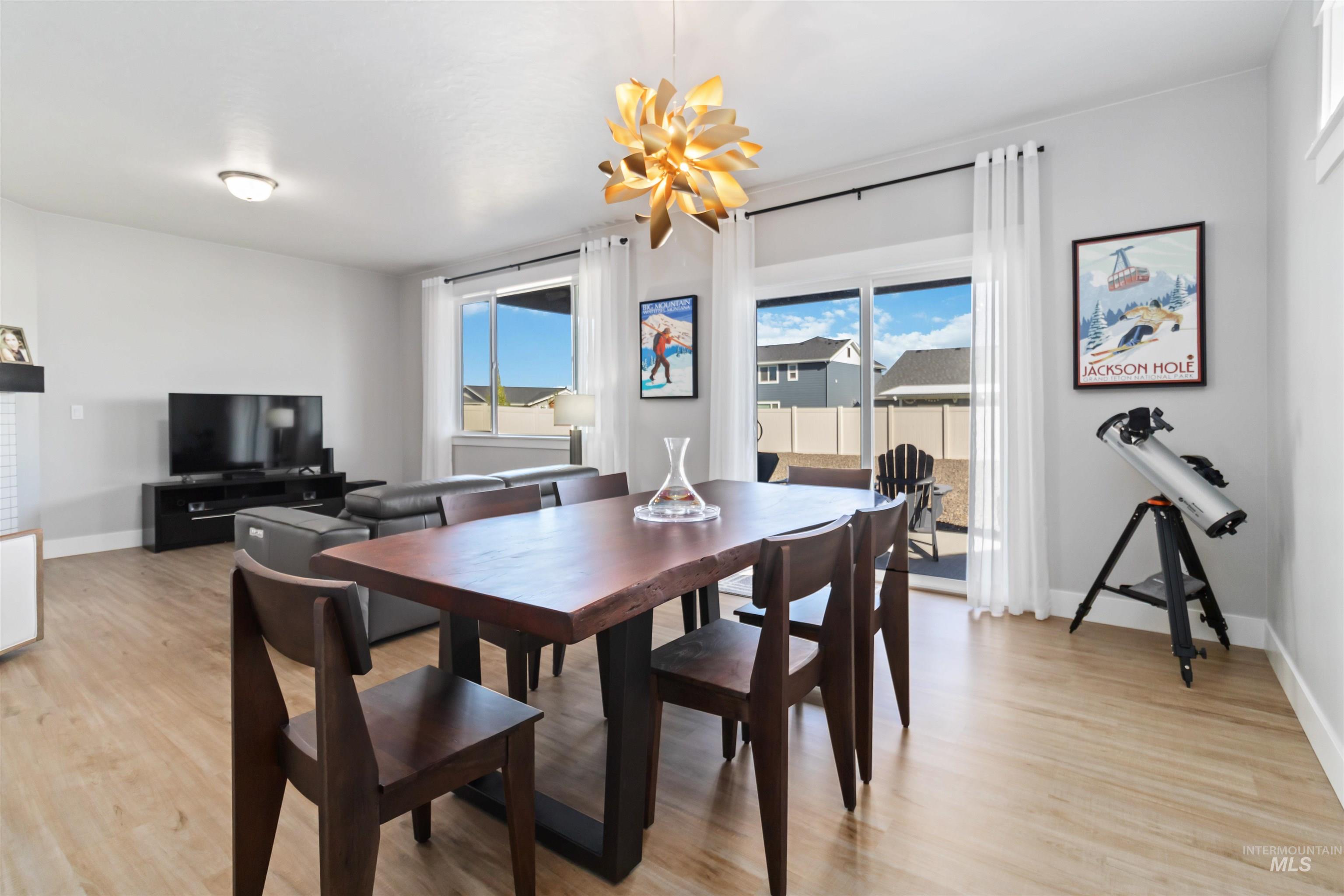 Dining room featuring plenty of natural light, light wood-type flooring, and a chandelier