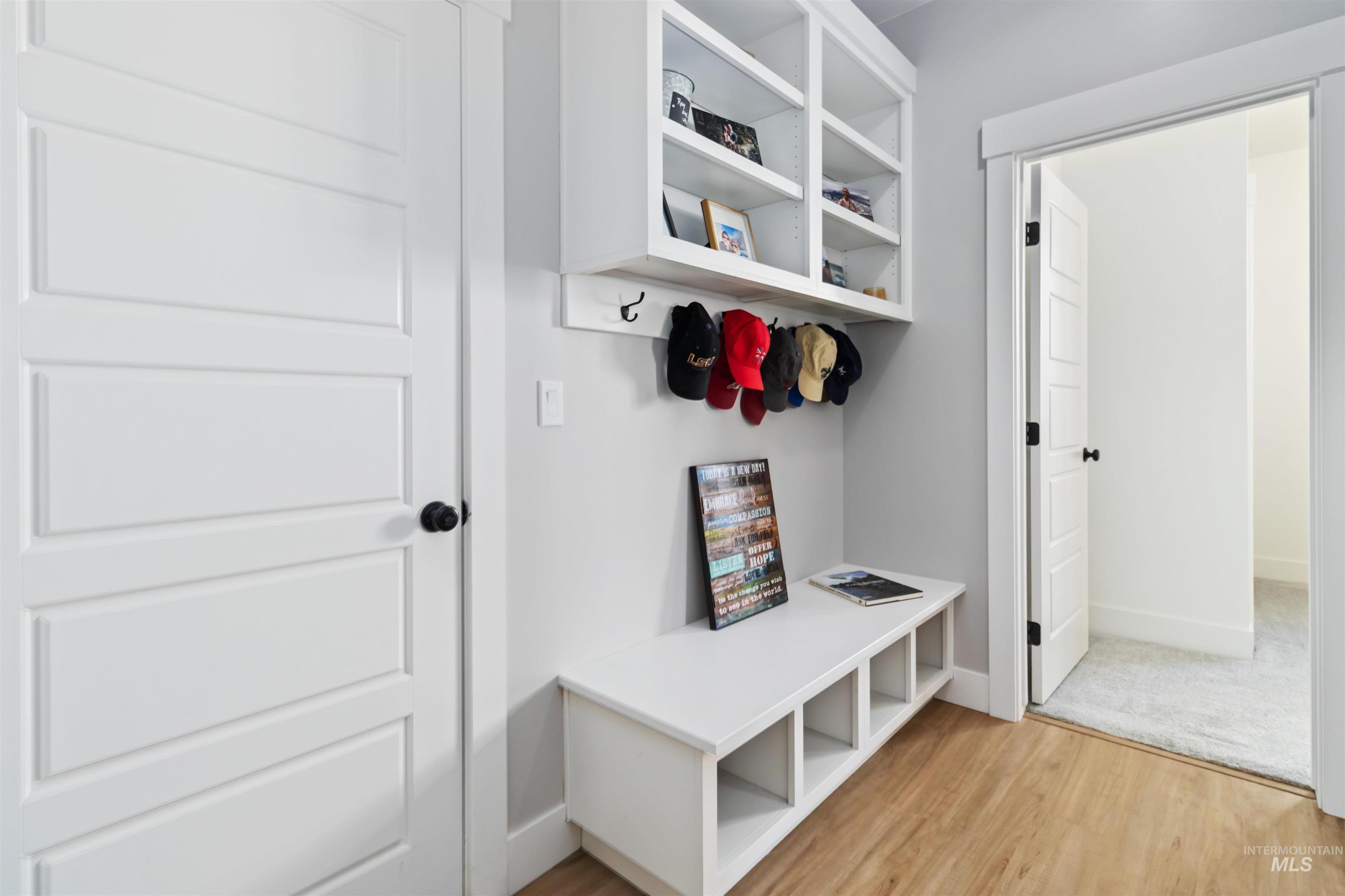 Mudroom with light wood finished floors and baseboards