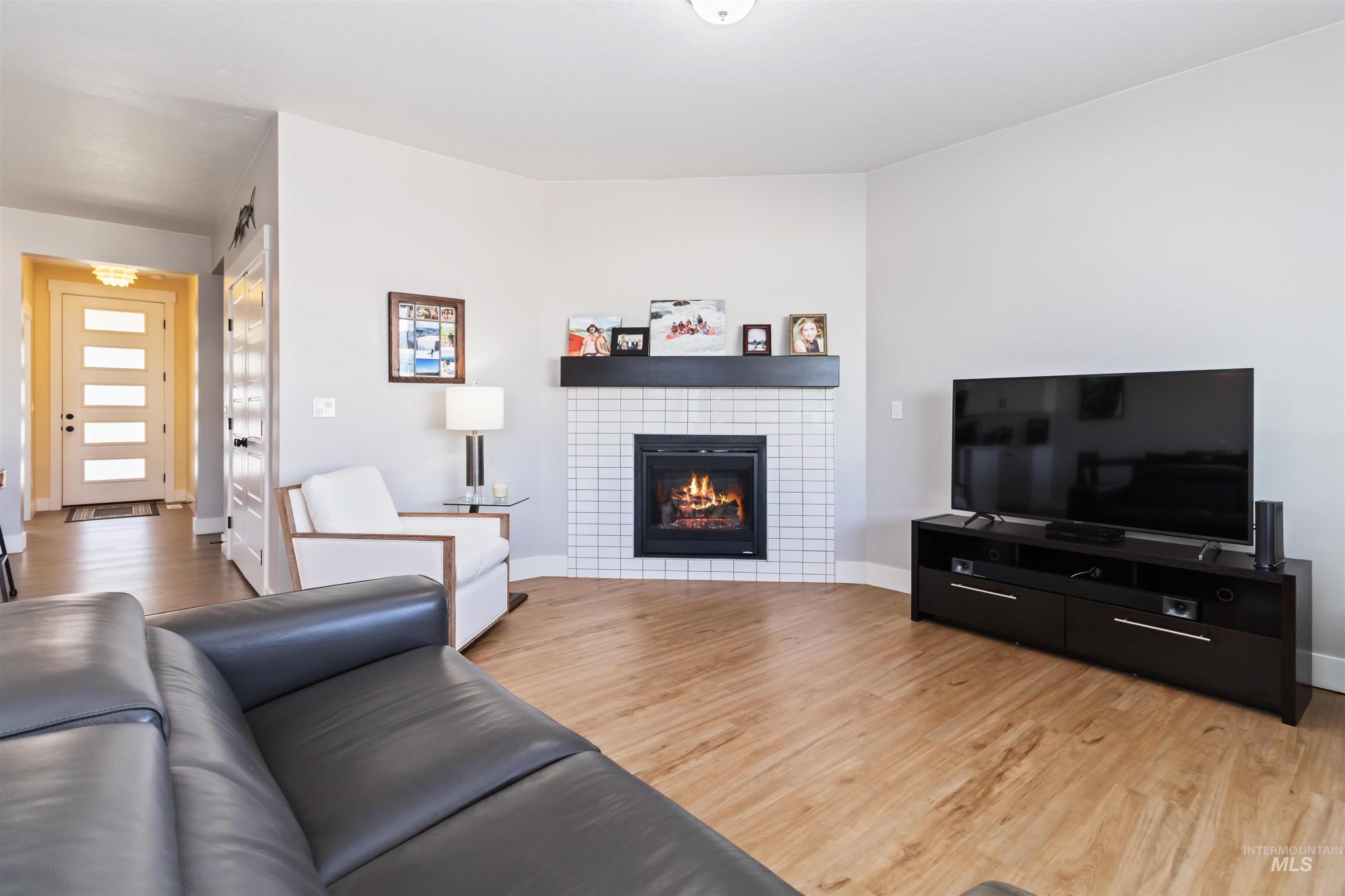 Living room featuring light wood-style flooring and a tiled fireplace